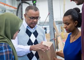 UBCO Engineering Professor Solomon Tesfamariam (centre) examines wood used in mass-timber buildings