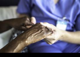 Patient and nurse holding hands