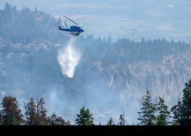 A helicopter attacks a wildfire from above